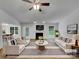 Bright, virtually staged living room with fireplace, neutral decor, and a ceiling fan at 12307 Poplar Forest Dr, Charlotte, NC 28278