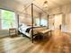 Main bedroom with wood floors, a four poster bed, and abundant natural light at 125 Todd Nw Dr, Concord, NC 28025