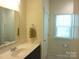 Cozy bathroom with white vanity, wood cabinets, and a window with natural light at 1311 Stonecroft Nw Ln, Concord, NC 28027