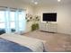 Well-lit bedroom featuring carpet floors, large windows and light colored walls and furnishings at 1311 Stonecroft Nw Ln, Concord, NC 28027