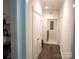 Hallway leading to a laundry room with dark hardwood floors and white trim at 1311 Stonecroft Nw Ln, Concord, NC 28027