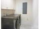 Well-equipped laundry room with washer, dryer, and overhead cabinet storage at 1311 Stonecroft Nw Ln, Concord, NC 28027