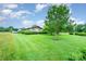 Landscaped backyard with spacious lawn, brick home, shed, and mature trees at 1410 Patterson St, China Grove, NC 28023