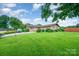 Charming brick home with a lush green lawn and mature trees creating a serene setting at 1410 Patterson St, China Grove, NC 28023