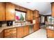 Traditional kitchen with wood cabinets, stainless steel dishwasher, tile floor, and view from window at 1410 Patterson St, China Grove, NC 28023