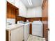 Bright laundry room with white washer, dryer, sink, and custom white and wood cabinets at 1410 Patterson St, China Grove, NC 28023