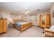 Spacious main bedroom with natural wood furniture, ceiling fan, carpet, and natural light from window at 1410 Patterson St, China Grove, NC 28023