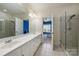 Bright Primary bathroom featuring double sinks, white cabinetry, tiled floor, and glass door shower at 14652 Villalonga Ln, Charlotte, NC 28277