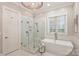 Modern bathroom with large glass enclosed shower and a soaking tub at 14652 Villalonga Ln, Charlotte, NC 28277