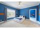Bright bedroom featuring blue walls, carpet, ceiling fan, a queen bed with a white comforter and blue accents at 14652 Villalonga Ln, Charlotte, NC 28277