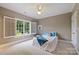 Cozy bedroom with neutral walls, ceiling fan, and a large window with a view of lush greenery at 14652 Villalonga Ln, Charlotte, NC 28277
