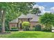 Expansive lawn and mature trees complement this all-brick home with its distinguished entrance and manicured shrubbery at 14652 Villalonga Ln, Charlotte, NC 28277