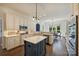 Bright kitchen with white cabinetry, stainless appliances, an island, and eat-in breakfast area with backyard views at 14652 Villalonga Ln, Charlotte, NC 28277