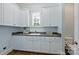 Bright laundry room with shaker cabinets and window and a view of a large laundry sink at 14652 Villalonga Ln, Charlotte, NC 28277