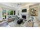 Bright living room with large windows, fireplace, TV, white walls, and two sofas at 14652 Villalonga Ln, Charlotte, NC 28277