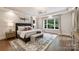 Main bedroom features neutral decor, tray ceiling, a ceiling fan, and large windows at 14652 Villalonga Ln, Charlotte, NC 28277