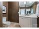 Classic powder room showcasing brown walls, a white vanity, and an elegant mirror at 14652 Villalonga Ln, Charlotte, NC 28277