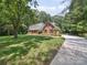 Beautiful brick home with a manicured lawn, mature trees, and a long driveway at 1518 Appaloosa Way, Gastonia, NC 28056
