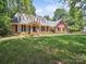Charming brick home featuring a well-manicured lawn and dormer windows for added natural light at 1518 Appaloosa Way, Gastonia, NC 28056