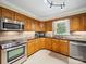 Efficient kitchen featuring wooden cabinetry and stainless steel appliances ready for culinary creations at 1518 Appaloosa Way, Gastonia, NC 28056
