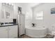 Bright bathroom with a soaking tub, white cabinets, and light blue countertops at 1738 Charlotte Hwy, Lancaster, SC 29720