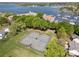 Aerial view of tennis courts, lakefront property, and neighboring houses and marina at 18679 Vineyard Point Ln, Cornelius, NC 28031