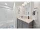 Bathroom featuring a vanity with a white countertop, modern fixtures, a frameless mirror, and a tiled shower at 18679 Vineyard Point Ln, Cornelius, NC 28031