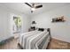 Cozy bedroom with wood floors, ceiling fan, white shiplap accent wall, and window views at 18679 Vineyard Point Ln, Cornelius, NC 28031