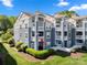 Well-maintained condo building with manicured lawns, multiple balconies, and charming architectural details at 18679 Vineyard Point Ln, Cornelius, NC 28031