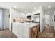 Bright kitchen featuring white cabinets, stainless steel appliances, and a stylish island with wood accents at 18679 Vineyard Point Ln, Cornelius, NC 28031