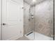 Elegant shower with glass door and natural stone tile, providing a spa-like experience in this bathroom at 18679 Vineyard Point Ln, Cornelius, NC 28031