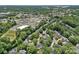 Aerial view of a neighborhood with mature trees, showing the homes and their proximity to commercial areas at 19746 Valiant Way, Cornelius, NC 28031