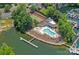 Aerial view of a community with a pool, tennis court, and waterfront access, highlighting the neighborhood's amenities at 19746 Valiant Way, Cornelius, NC 28031