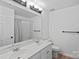 Bright bathroom with double sinks, a large mirror, a shower with curtains, and wood-look flooring at 19746 Valiant Way, Cornelius, NC 28031