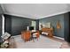 Cozy home office with a wooden desk, piano, and dark accent wall at 19746 Valiant Way, Cornelius, NC 28031