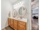 Bathroom with a double sink vanity with two round mirrors and view into a bedroom at 211 Tyndale Ct, Waxhaw, NC 28173