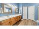 Bathroom features a double vanity, framed mirrors, and wood-look flooring at 211 Tyndale Ct, Waxhaw, NC 28173