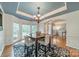 Cozy dining area with a tray ceiling, elegant chandelier, and ample natural light through large windows at 211 Tyndale Ct, Waxhaw, NC 28173