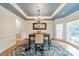 Stylish dining room featuring a tray ceiling, contemporary chandelier, and custom wainscoting at 211 Tyndale Ct, Waxhaw, NC 28173