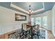 Elegant dining room showcasing a modern chandelier, tray ceiling, and wainscoting for sophisticated meals at 211 Tyndale Ct, Waxhaw, NC 28173
