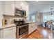 Kitchen featuring stainless steel appliances, granite countertops, and white cabinetry at 211 Tyndale Ct, Waxhaw, NC 28173