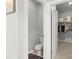 Bathroom features a toilet and a view into a walk-in closet with hanging clothes at 219 Broadleaf Dr, Denver, NC 28037