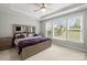 Bright bedroom features a large window, ceiling fan, and decorative tray ceiling at 219 Broadleaf Dr, Denver, NC 28037