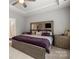 Bedroom featuring ceiling fan, tray ceiling, and bedside tables with decorative accessories at 219 Broadleaf Dr, Denver, NC 28037