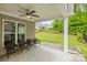 Inviting covered patio with a ceiling fan and comfortable seating overlooking the landscaped backyard at 219 Broadleaf Dr, Denver, NC 28037