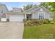 Charming home featuring gray siding, stone accents, well-manicured lawn, and a two-car garage at 219 Broadleaf Dr, Denver, NC 28037