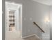 Hallway with access to a bathroom and a staircase, illuminated by wall sconces at 219 Broadleaf Dr, Denver, NC 28037
