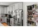 Pantry and stainless steel refrigerator in a kitchen with gray cabinets at 219 Broadleaf Dr, Denver, NC 28037