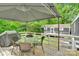Backyard wood deck featuring covered seating around a patio table with views of the lush tree line at 2289 Mccloud St, Denver, NC 28037