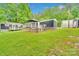 Home featuring a well-maintained lawn, multiple outbuildings and a wood deck, great for outdoor enjoyment at 2289 Mccloud St, Denver, NC 28037